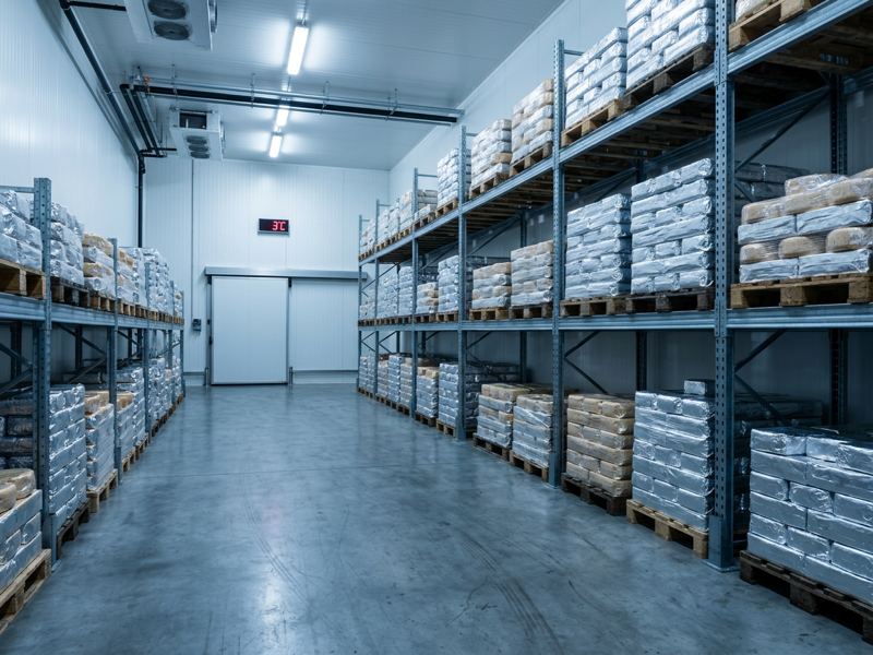 Vormkisten met foliekaas opgeslagen bij gecontroleerde temperatuur in de koelcellen